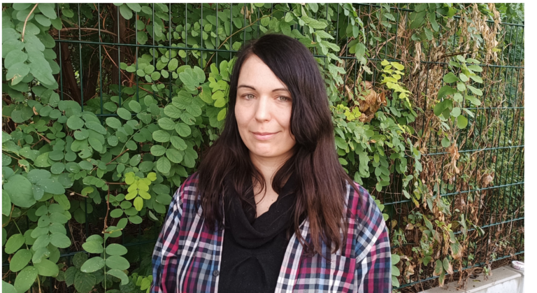 Anne vor einem Hintergrund aus grünen Blättern