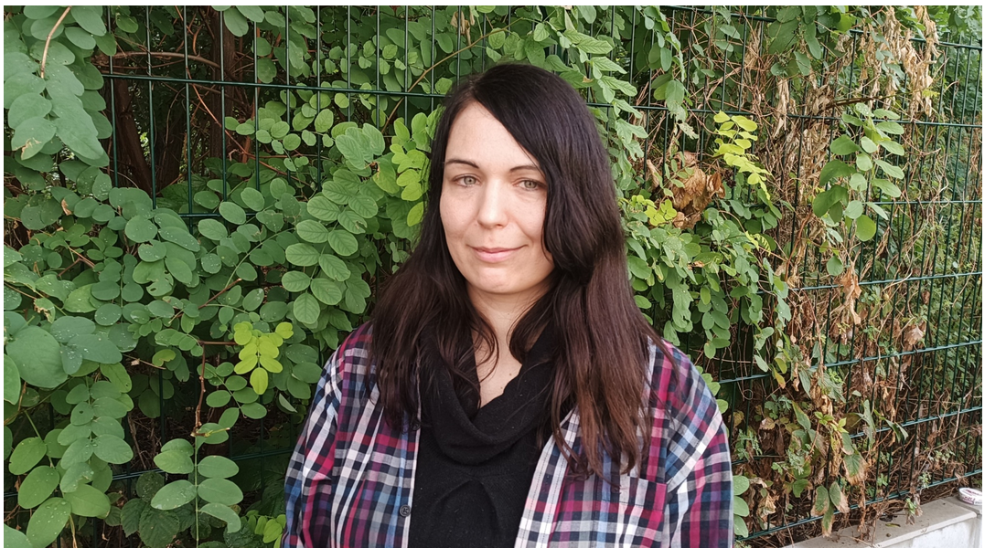Anne vor einem Hintergrund aus grünen Blättern